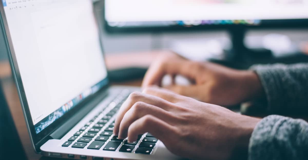 Person typing on a laptop keyboard