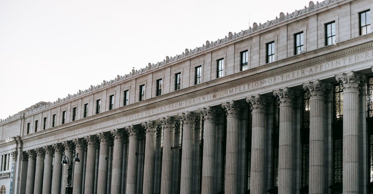 From below of facade of famous James A Farley Post Office with columns and windows in center of New York at daytime