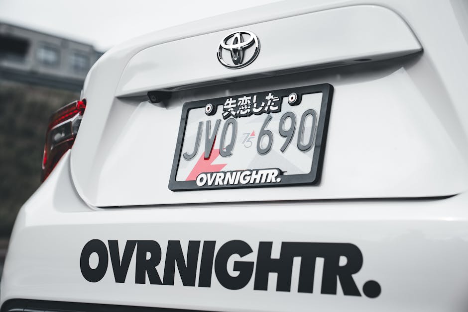 A detailed view of a car's custom license plate with Japanese characters.