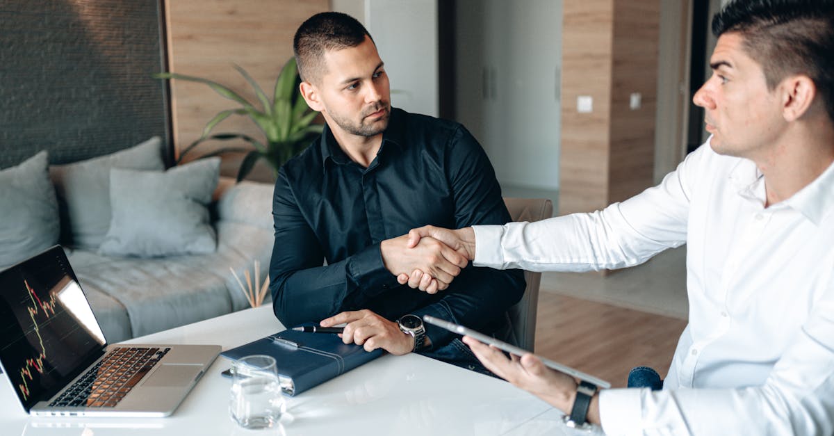 Two businessmen shaking hands in a modern office environment, sealing a deal.