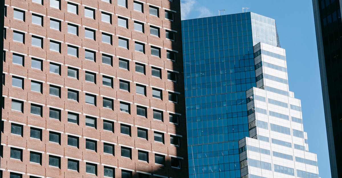 Low-angle view of modern skyscrapers against a clear blue sky.