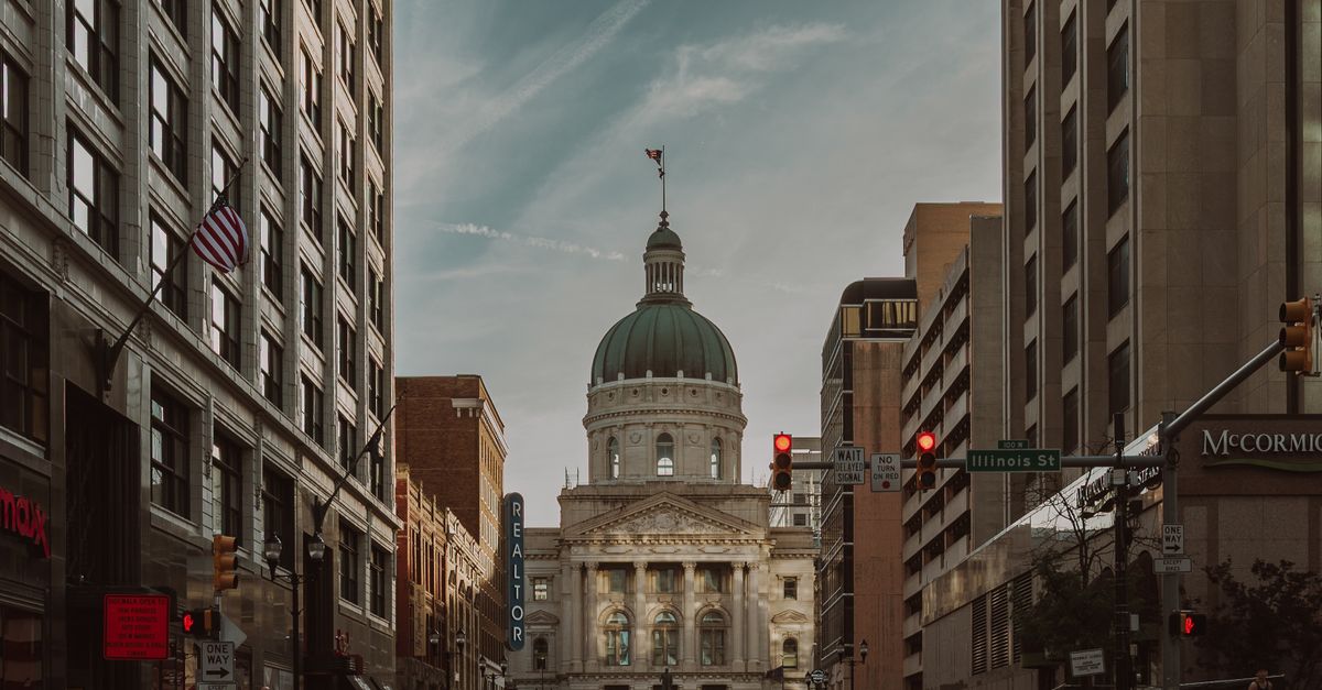 A historic courthouse dome framed by tall buildings on a city street, showcasing urban architecture.