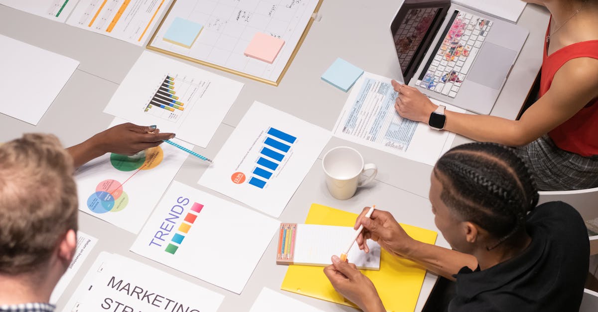 Overhead shot of diverse team analyzing marketing strategies with charts and graphs.