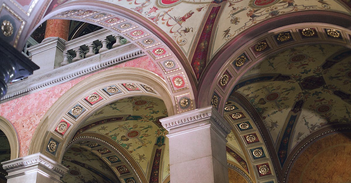 From below of aged stone columns under ornamental ceiling of classic palace in city