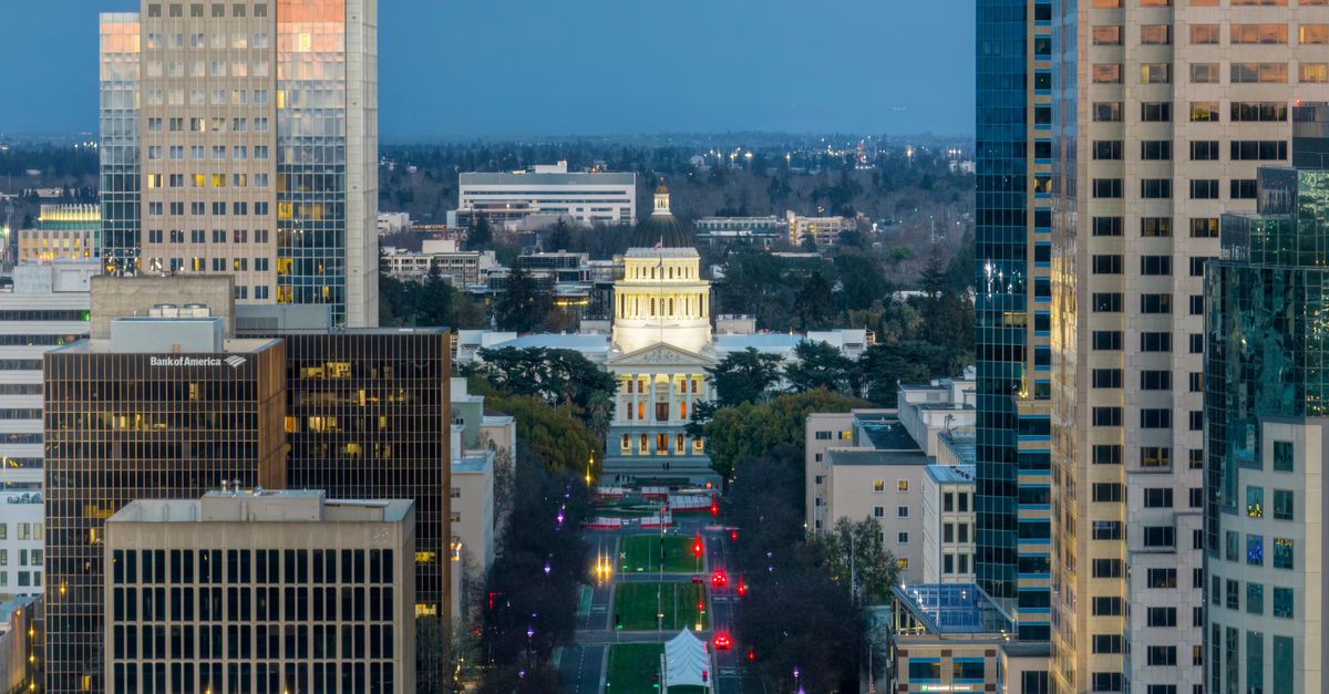 Aerial view of the Sacramento skyline featuring the California State Capitol illuminated at dusk.