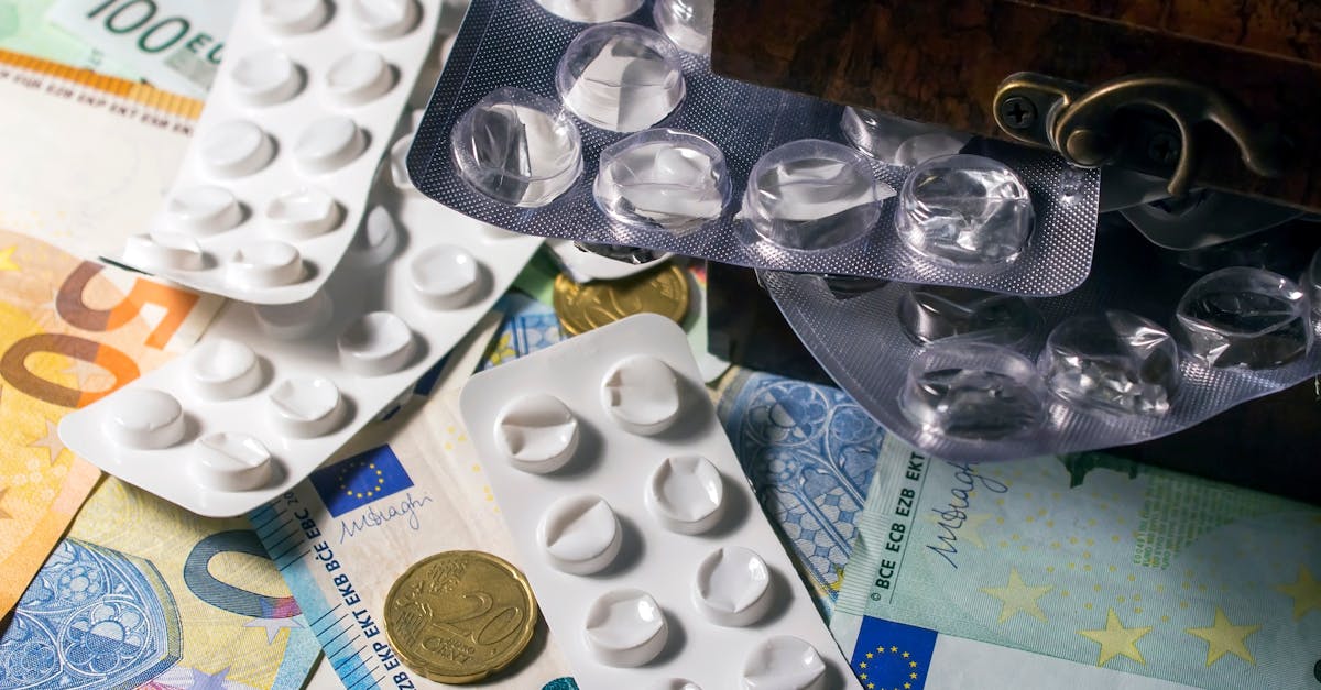 Blister packs of medication placed on Euro banknotes, illustrating healthcare expenses.