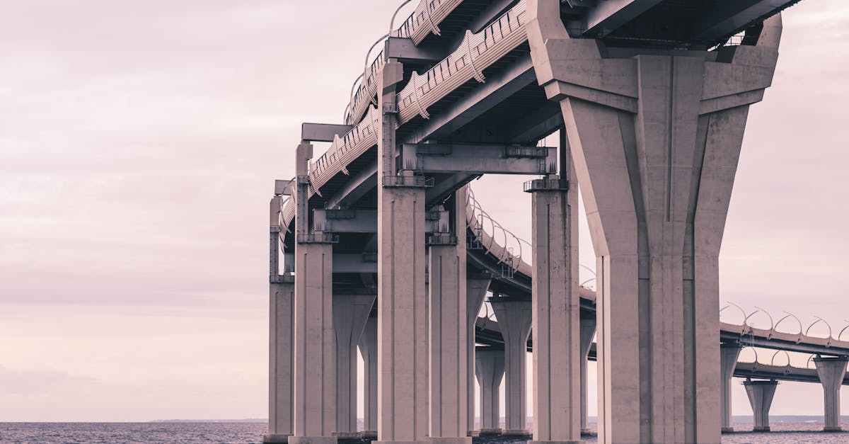 A stunning view of a concrete bridge extending over peaceful waters during the day.