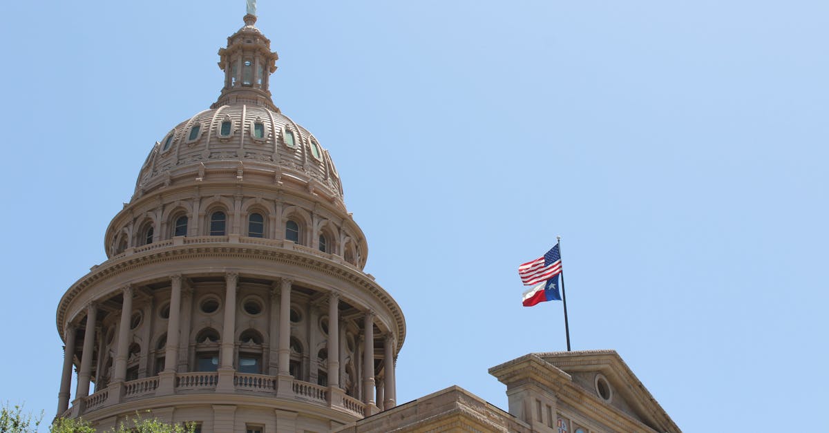 Low angle view of the Texas State Capitol dome and flags in Austin, Texas.
