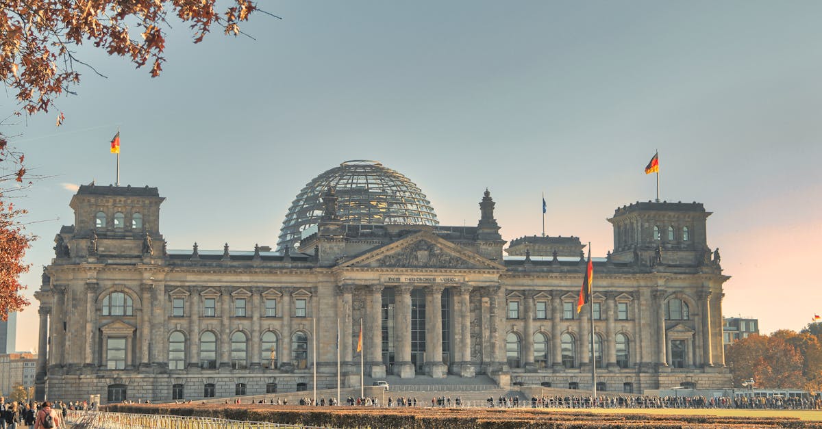 The historic Reichstag Building in Berlin, Germany, featuring a glass dome and autumn foliage.