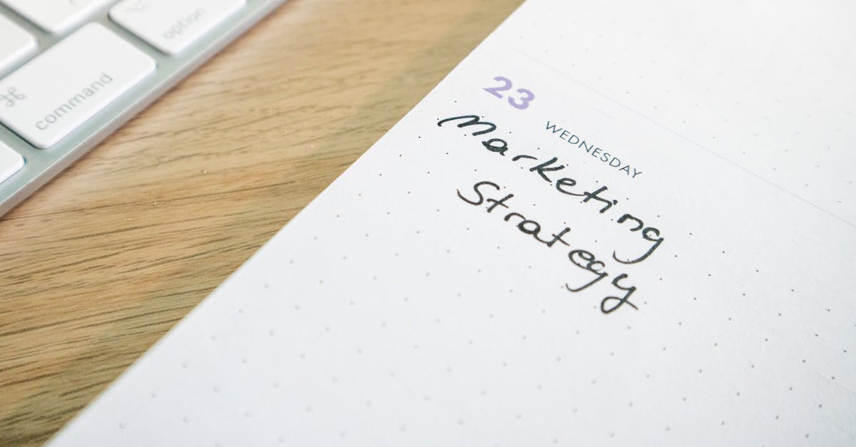 Close-up of a planner with 'Marketing Strategy' handwritten alongside keyboard.
