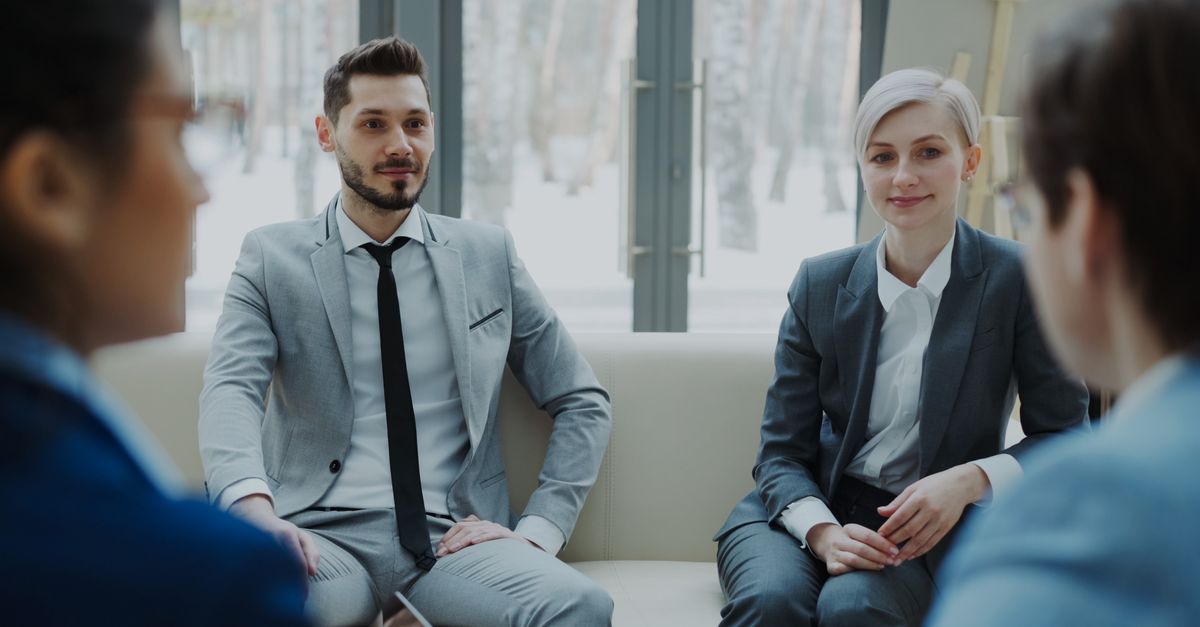 Business meeting with professionals in suits discussing in a modern office.