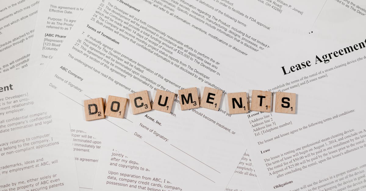 Top view of scrabble tiles spelling 'DOCUMENTS' on various contracts and agreements.