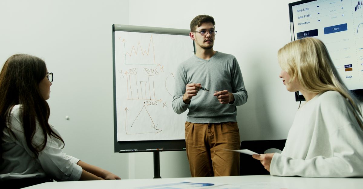 Adults discussing financial charts during a teamwork session.