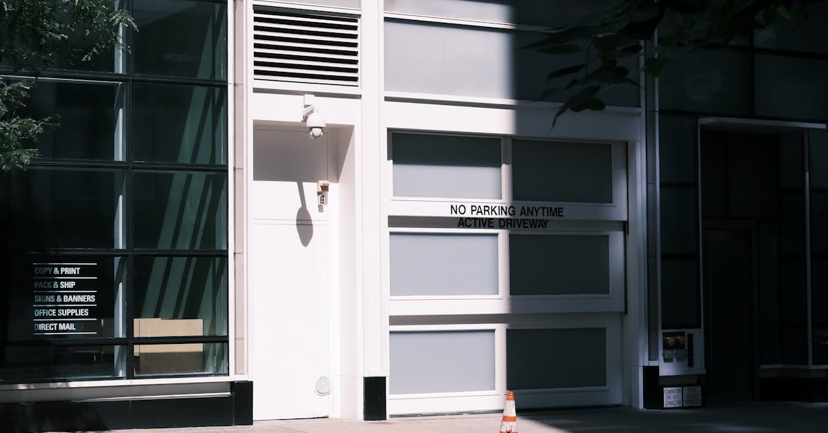 Contemporary building facade with 'No Parking Anytime' sign and traffic cone.