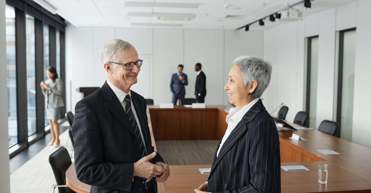 Business professionals engaged in a conversation in a modern conference room setting.