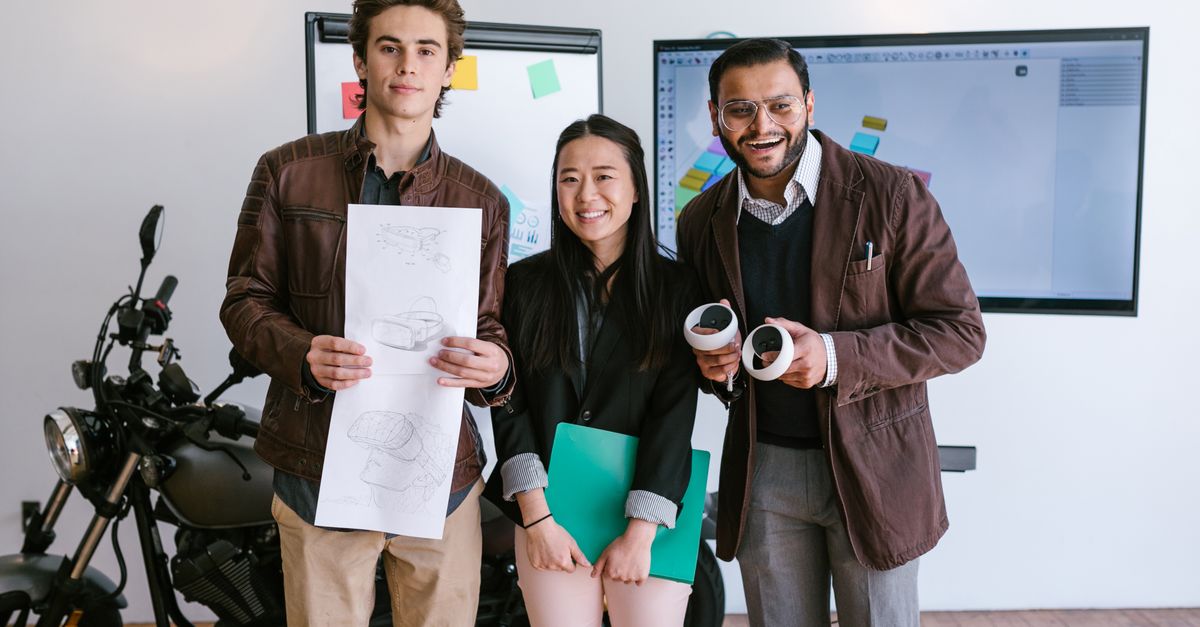 Diverse young entrepreneurs showcasing a new product prototype in a modern office.