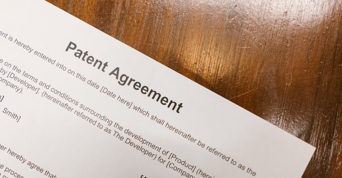 Detailed close-up of a patent agreement document on a polished wooden table.