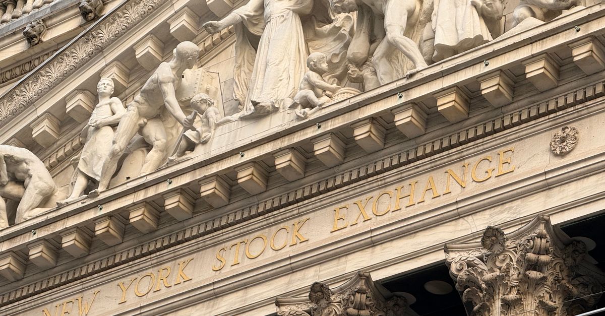 Ornate façade of the New York Stock Exchange featuring intricate stone sculptures during daylight.