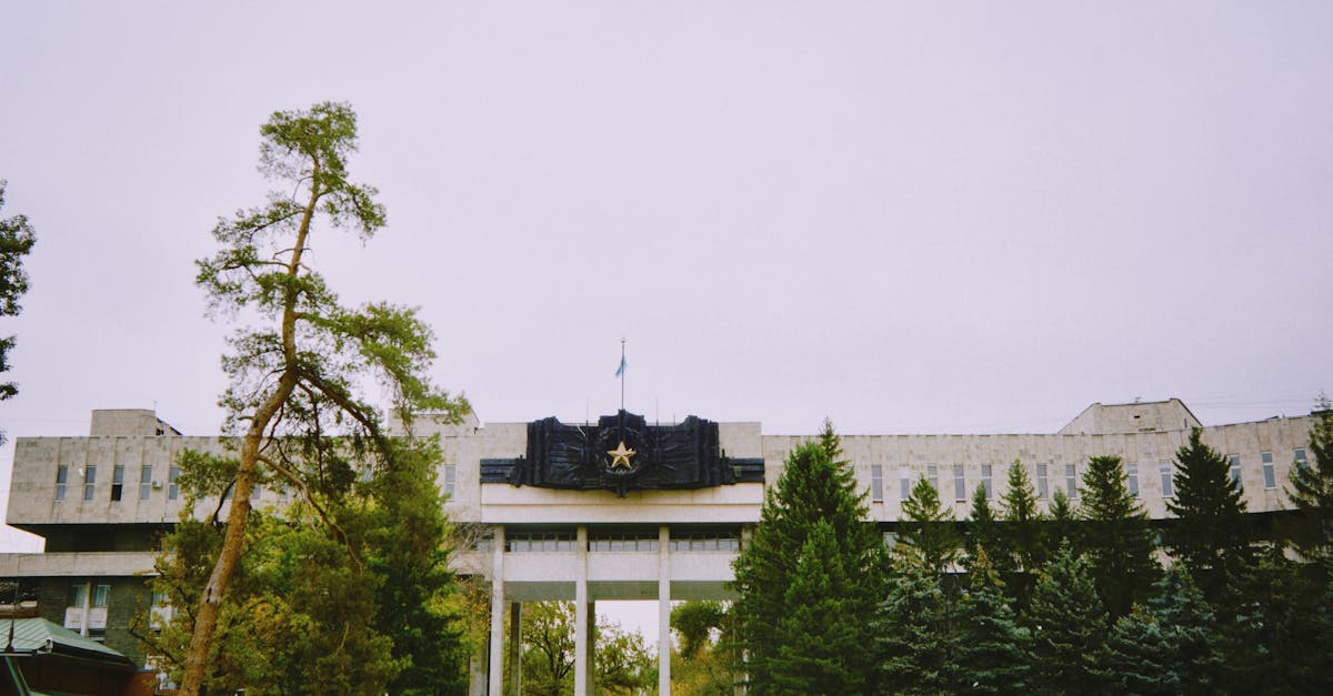 Outdoor view of a government building surrounded by trees in Almaty, Kazakhstan.