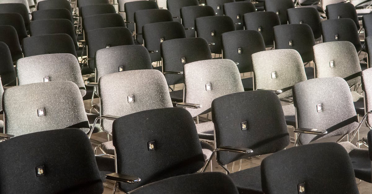 Rows of black and gray chairs in an auditorium, showcasing comfort and style.