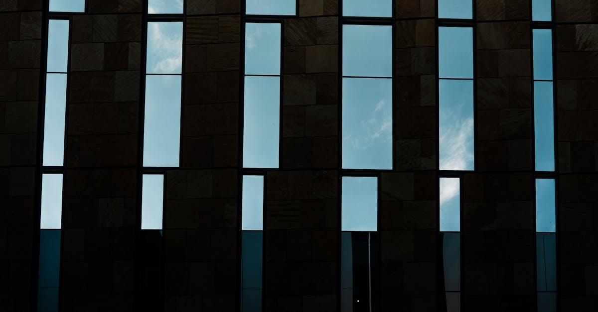 Geometric windows on a modern building facade reflecting a clear sky in Phoenix, Arizona.