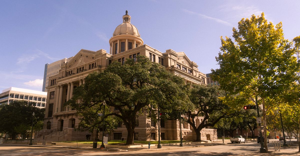 Stunning view of a historic courthouse building with trees, in downtown Houston, Texas.