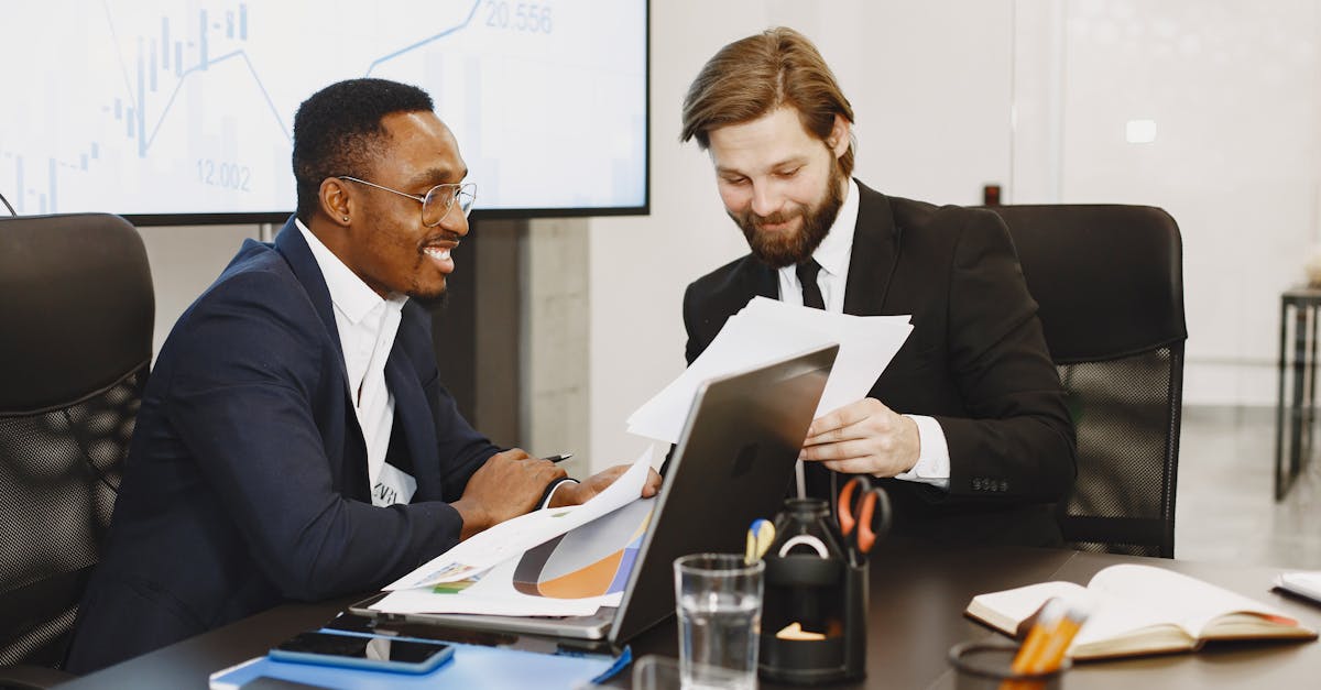 Two businessmen discussing documents in a modern office, fostering teamwork.