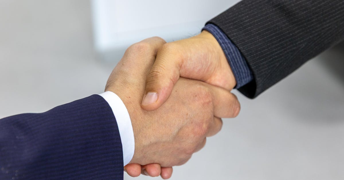 Close-up of two businessmen shaking hands, symbolizing agreement and partnership.