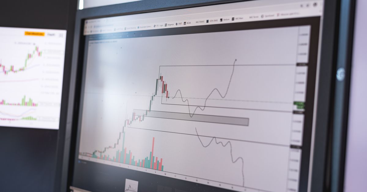 Close-up of stock market analysis charts on a monitor, showcasing market trends.