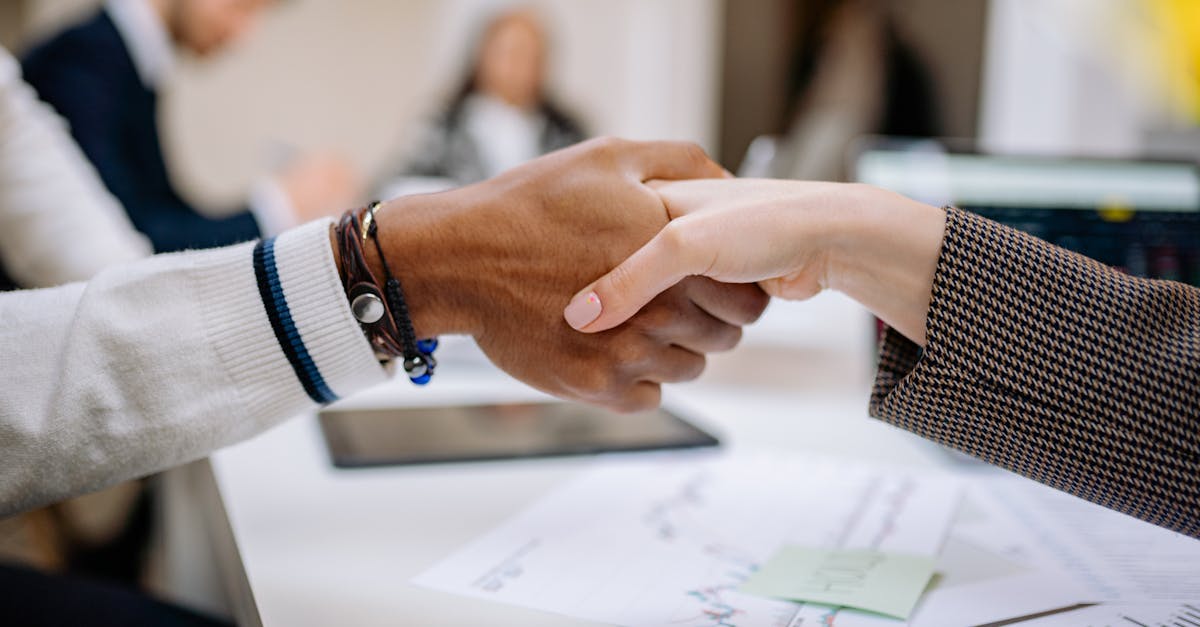 Diverse business professionals exchanging handshake in an office environment, symbolizing agreement.