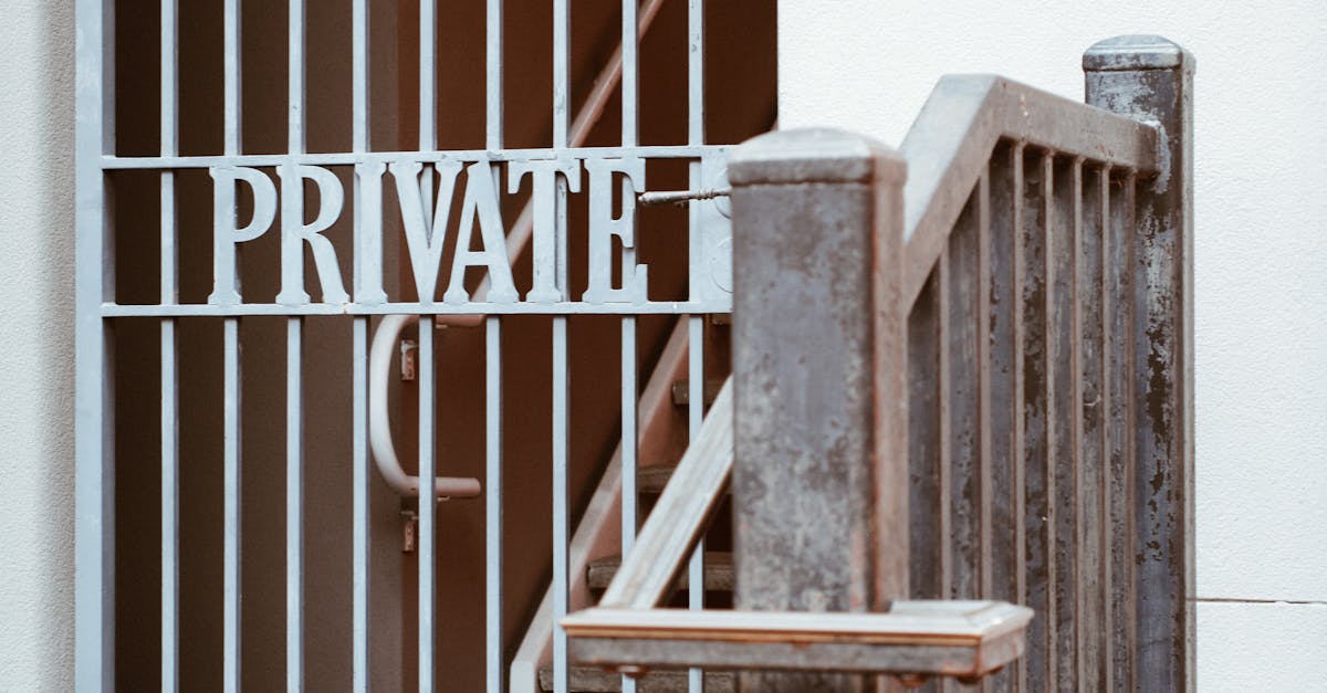 Close-up of a gated entrance marked 'PRIVATE' with vintage metal bars and stairway.