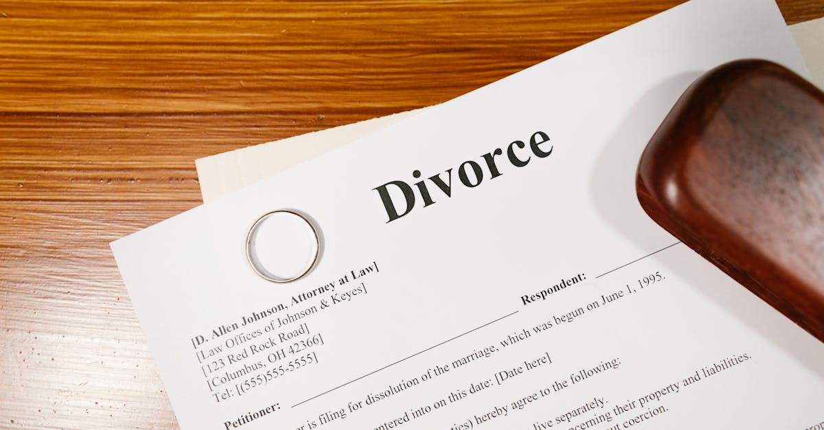 Close-up of a divorce document and wedding ring on a lawyer's desk.