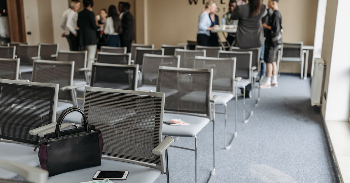 An empty conference room with chairs and a group of people gathered at the back.