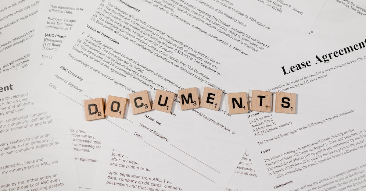 Top view of scrabble tiles spelling 'DOCUMENTS' on various contracts and agreements.