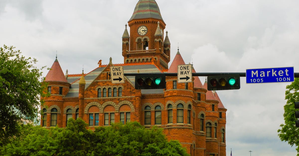 View of the iconic Dallas County Courthouse with its red brick facade and clock tower, capturing historic architecture.
