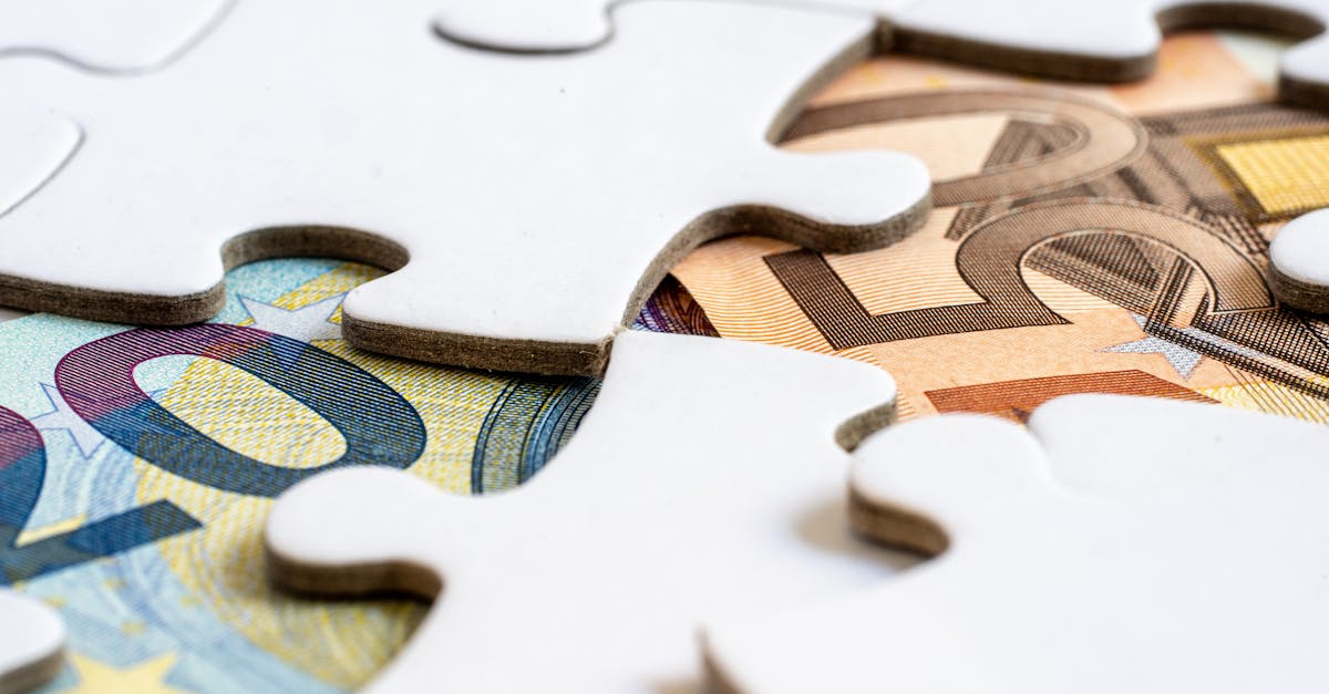 Close-up of euro banknotes revealed under puzzle pieces, symbolizing financial solutions.