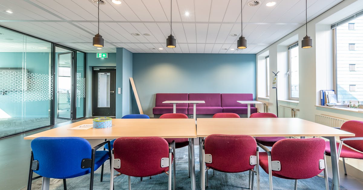 Contemporary office interior with colorful chairs and ample natural light.