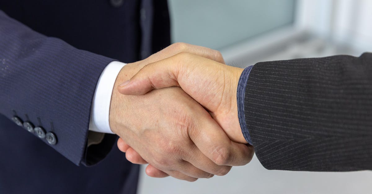 Close-up of two business professionals shaking hands, symbolizing partnership and collaboration.