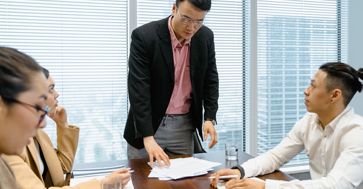 Colleagues engaged in a focused business discussion in a modern office setting.