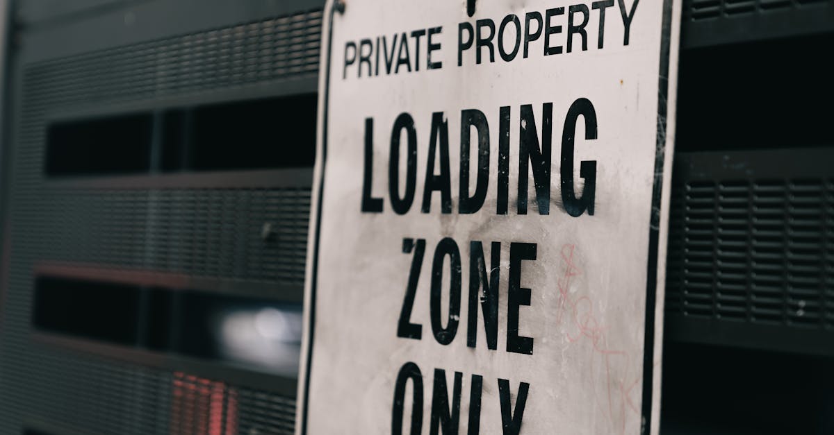 Close-up of a private property loading zone only sign with urban backdrop.