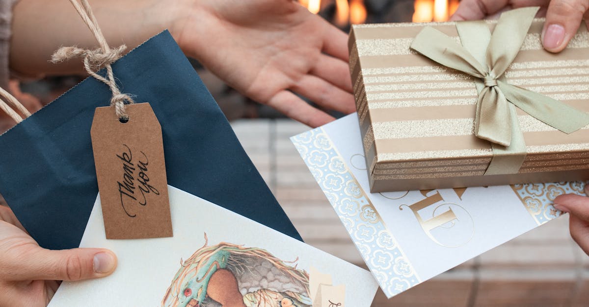 Close-up of hands exchanging beautifully wrapped gifts and thank you cards with a warm fireplace background.