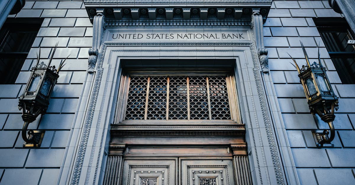 From below classic styled historic building of United States National Bank with wooden doors and vintage lanterns located in Portland