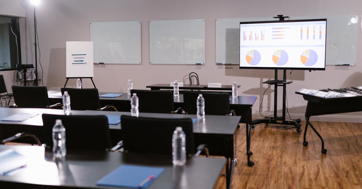 Modern conference room with projector, graphs, chairs, and bottled water setup for presentation.