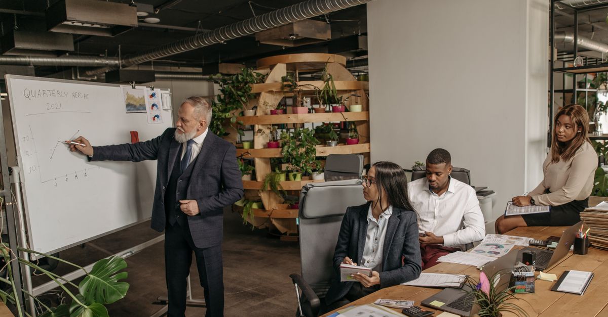 Team in a modern office discussing quarterly earnings with a presentation.