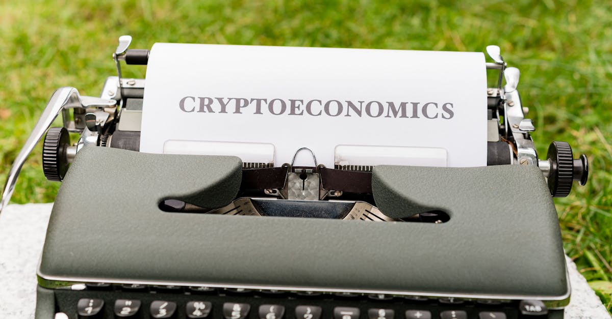 An antique typewriter with cryptoeconomics text on paper against a grassy background.