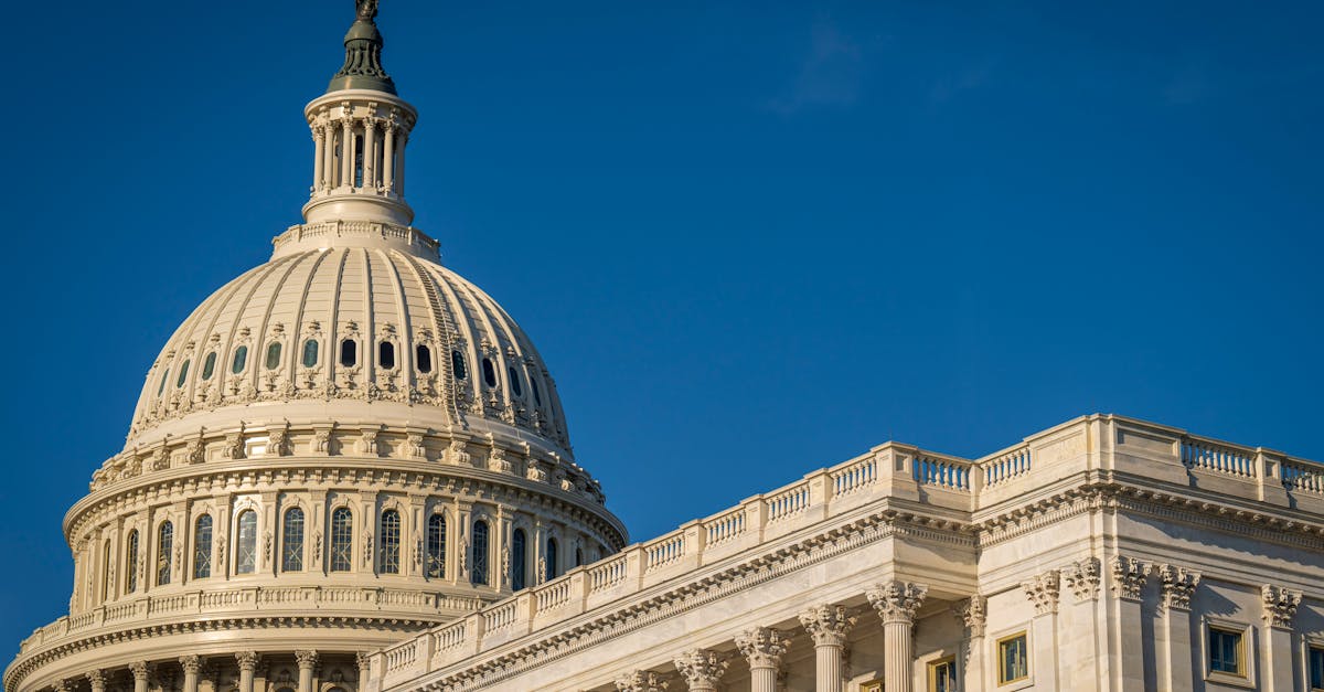 The iconic dome of the United States Capitol against a clear blue sky, showcasing its classical architecture.