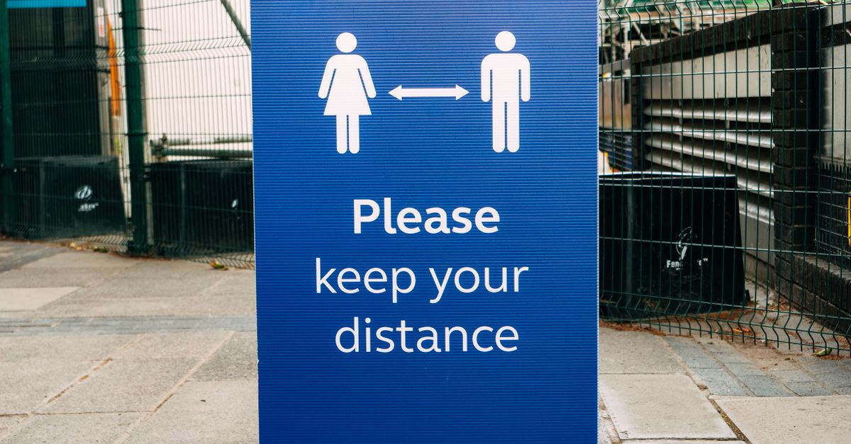 Banner with inscription Please Keep Your Distance and arrow between human figures on street during coronavirus epidemic
