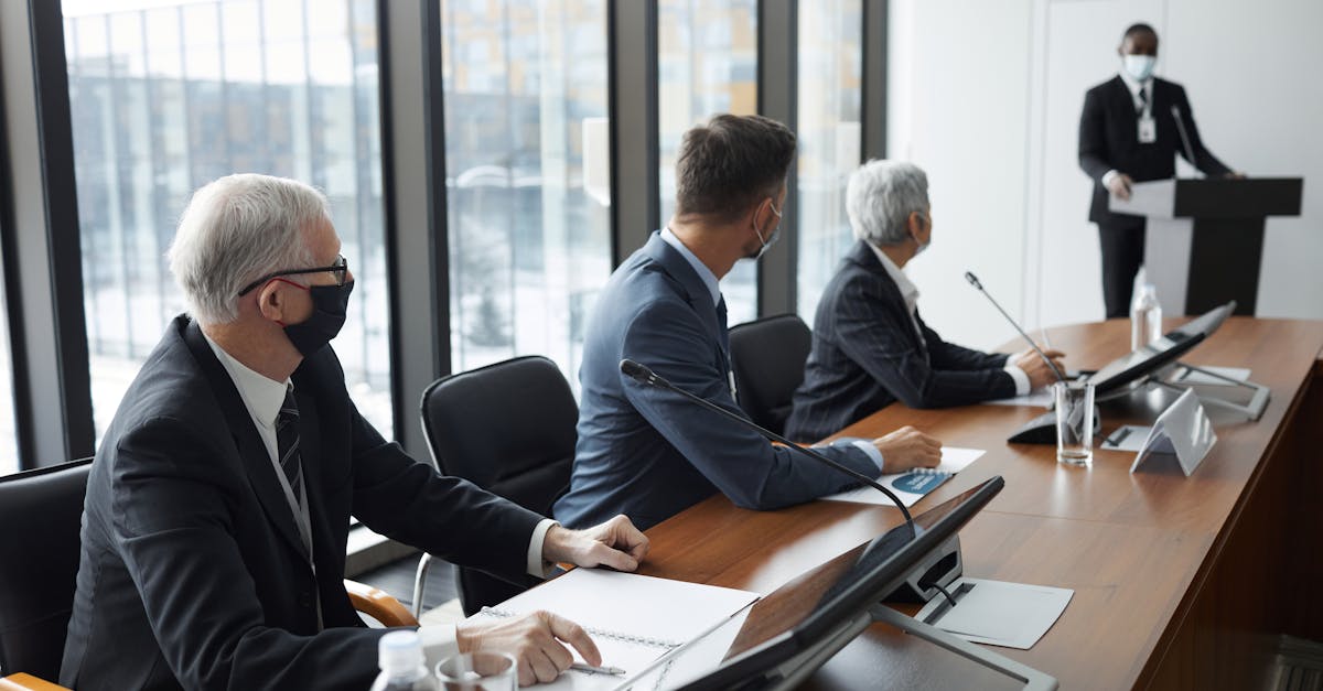 Business professionals discussing in a conference room with safety measures like face masks.