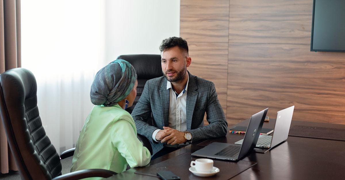 Two business colleagues discuss strategies during an office meeting, fostering teamwork.
