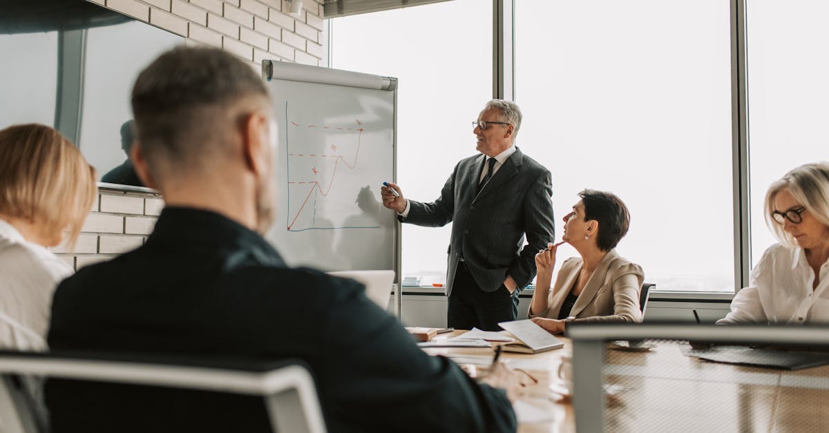 Senior leader presenting growth charts in a business meeting with colleagues in a modern office setting.